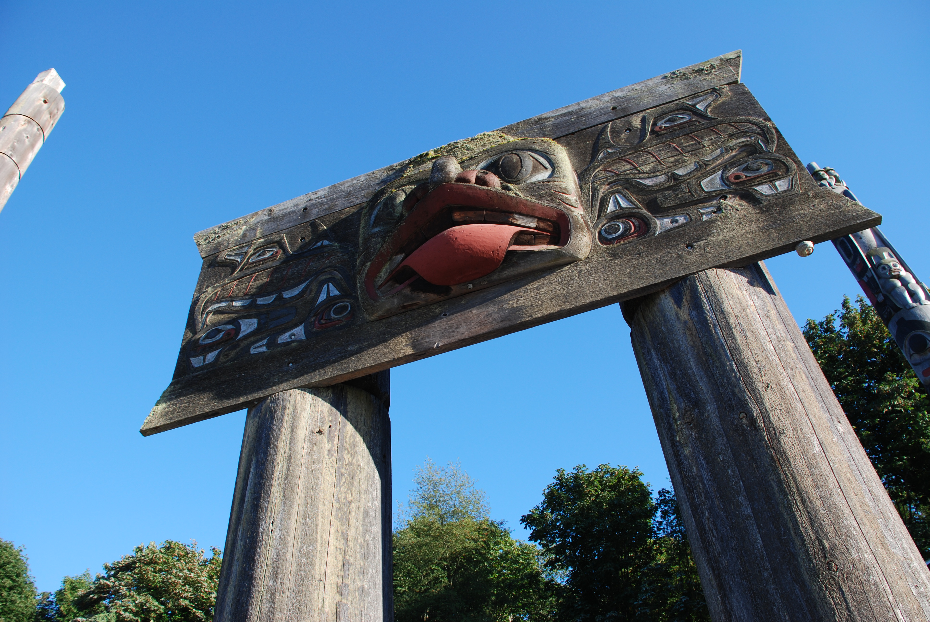 A totem pole depicting a salmon and two people adorns the tribal