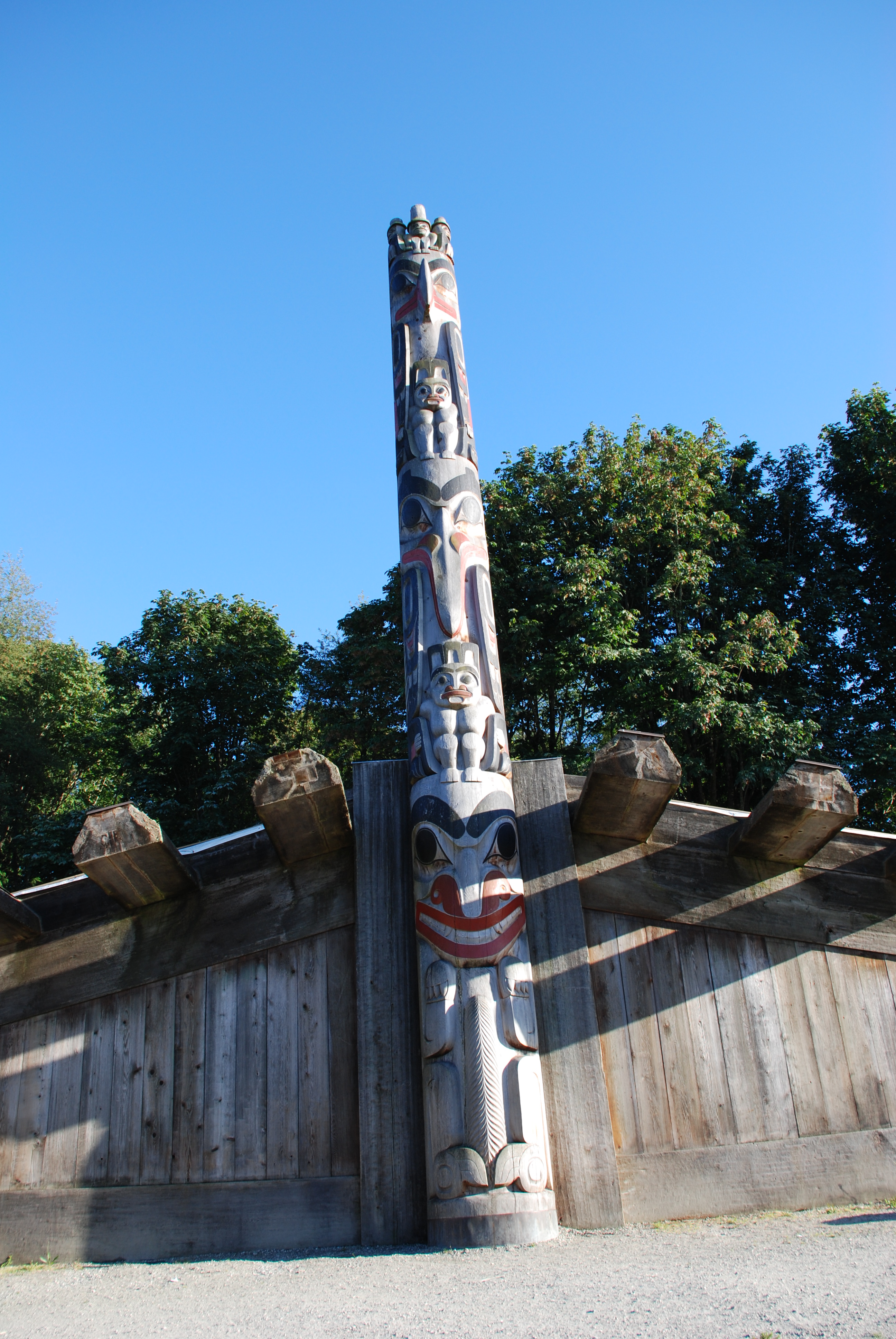 A totem pole depicting a salmon and two people adorns the tribal